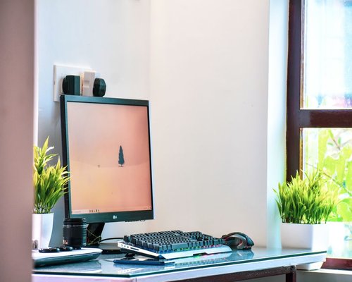 A modern setup of a clean sleek flat-screen monitor placed inside a well-lit home workspace in Yogyakarta